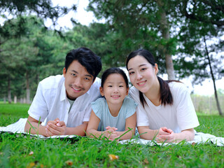 Happy family of three playing in the park