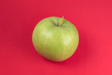 Green apple on the red background