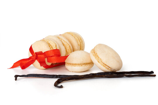Vanilla macaroons tied with a red ribbon with vanilla pods