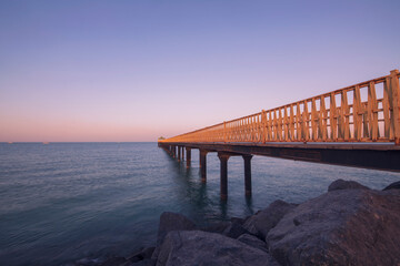 Fototapeta na wymiar Long steal bridge in the sea for watching sunrise and sunset.