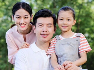 Happy family of three playing in the park