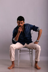 Man in blue shirt sitting on the chair