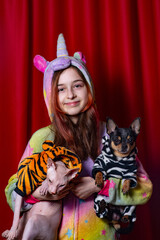 pets and owners. girl, cat and her dog on a red background. A girl with a cat and a dog in her arms.