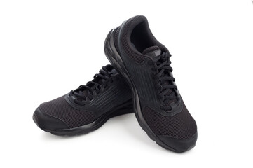 Black sneakers isolated on white background. Stylish black sneaker made from a combination of faux leather and textile material and rubber sole. Casual shoes. Running shoes.