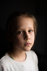Portrait of a calm, sad girl on a dark background. Selective Focus