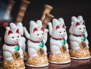 Maneki-Neko Japanese lucky waving beckoning cat in shop window