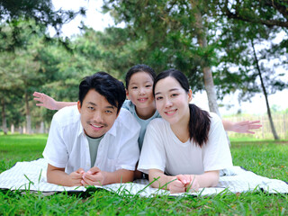 Happy family of three playing in the park