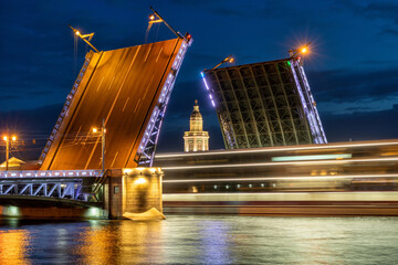 Fototapeta na wymiar Divorced Palace Bridge at night in St. Petersburg, view of Kunstkamera and a passing ship.