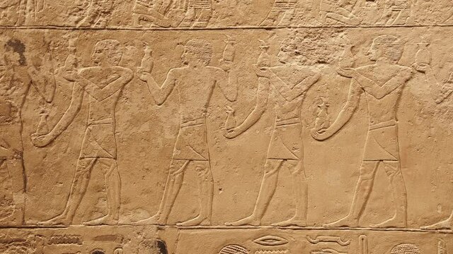 Stone wall with carved ancient Egyptian bas relief