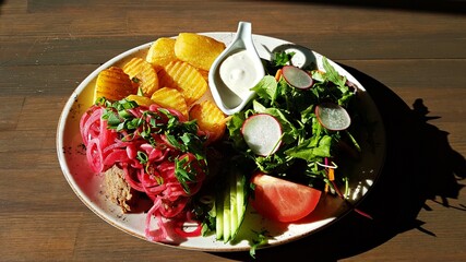 Cooked with meat cuts and fried potatoes with mixed vegetable salad on a plate