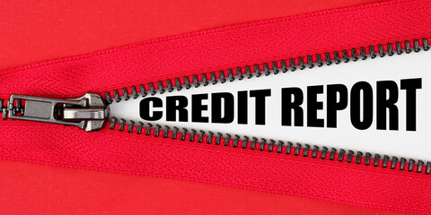 Against the background of red fabric, a zipper opens, on the white surface the inscription - CREDIT...