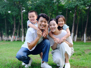 Fototapeta premium Happy family of four playing in the park