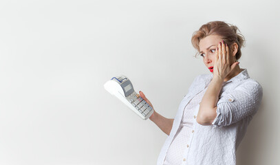The woman wonders how much money she spent looking at the calculator. Family budget, concept,...