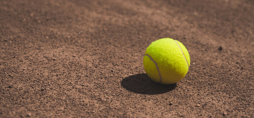 Close-up of yellow tennis ball on clay tennis court. Sport. Lifestyle.