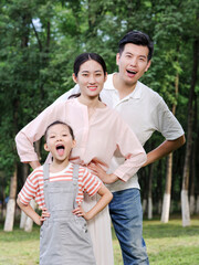 Happy family of three playing in the park