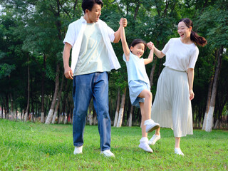 Happy family of three playing in the park