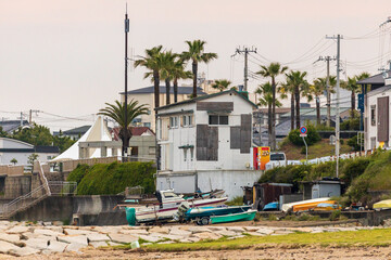 Small fishing boats docked on land under old building and palm trees