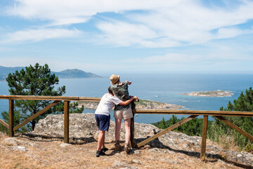 Fototapeta na wymiar Couple of hikers observing the coast from a viewpoint