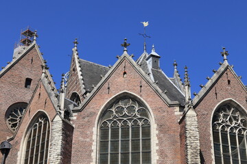 Fototapeta na wymiar Amsterdam Oude Kerk Church Exterior Detail Against a Blue Sky, Red Light District