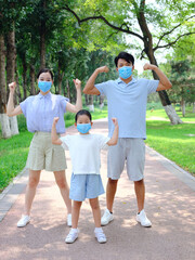A young family of three with masks