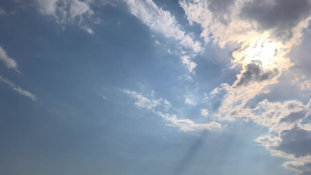 Low angle view TimeLapse of Beautiful sunny blue sky with bright sun shining on tropical summer horizon in vibrant sunlight, sunbeam n sun ray flares with white cumulus clouds at midday sunshine day