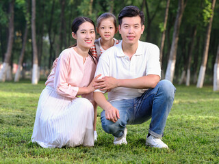 Happy family of three playing in the park