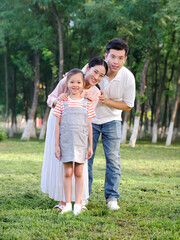 Happy family of three playing in the park