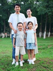 Fototapeta premium Happy family of four playing in the park