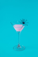 Pink neon cocktail on blue background with decorative flower.