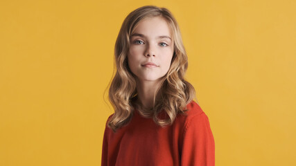 Attractive wavy haired teenage girl in red sweater looking confi