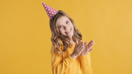 Beautiful excited teenager girl wearing birthday hat looking che