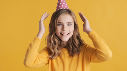 Cheerful teenage girl in party hat happily posing on camera cele