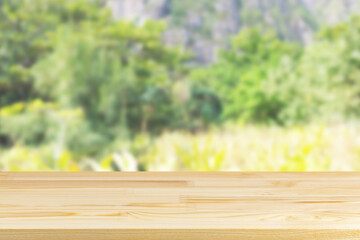 wood table top on blur plants and mountains background