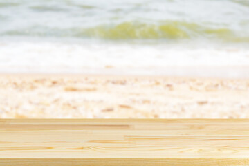 wood table top on blur seaside beach with shells background
