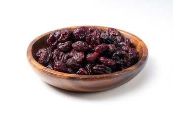 Dried cranberries in a wooden bowl on a white background.