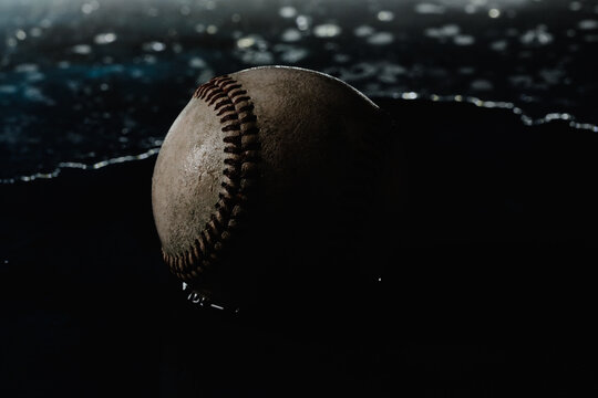 Dark Moody Vintage Baseball In Water For Rain Delay Or Game Concept Closeup.