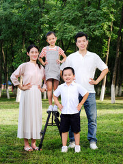 Happy family of four playing in the park