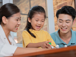 Happy family of three doing molecular structure model together