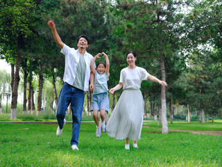 Happy family of three playing in the park