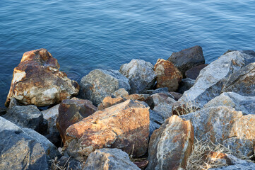 Large stones lining a yacht harbor at the shoreline