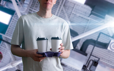 person holding a tray with couple of coffee paper cups