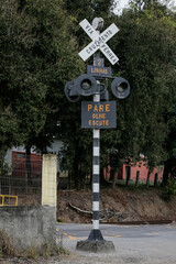Um conjunto de placas de travessia de ferrovia sinaliza o caminho para o trem de cargas, destacando...