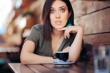 Funny Woman Biting Her Lips Having a Cup of Coffee in a Restaurant