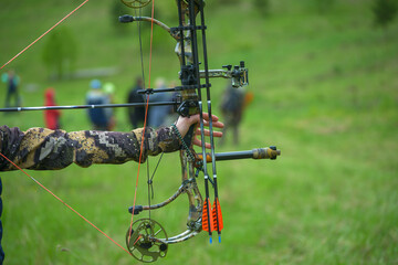 professional archer shooting with modern longbow at forest 