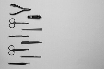 Set of manicure tools on grey background, flat lay. Space for text