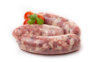 Raw homemade breakfast sausages decorated with tomato and basil leaf, isolated on a white background.