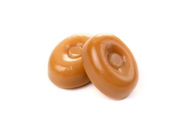 Two caramel candies on a white background close-up.