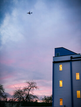 airplane over towers at sunset