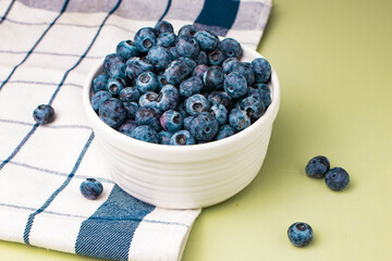 Bowl of ripe blueberries on towel