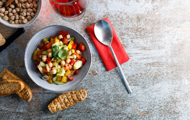 Homemade chickpea salad. Homemade healthy vegan salad, with chickpea , tomato, cucumber, paprika served in a bowl. Healthy meal, on a dinner table.